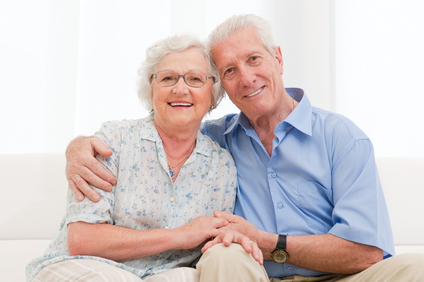 Happy smiling senior couple embracing together at home